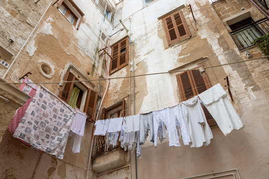 Patio interior de casas antiguas y decadentes, con ropa tendida, en un pueblo de la regi&oacute;n de Puglia  en Italia