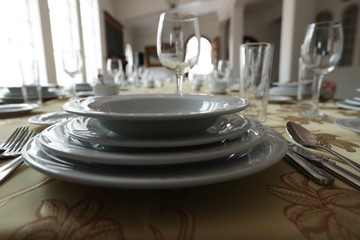 platos sobre mesa con copa de vino al fondo