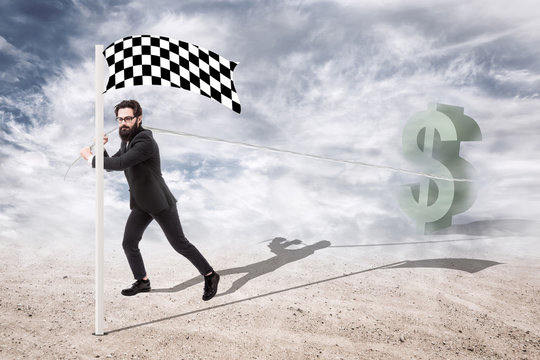 bearded businessman in suit pulls dollar symbol to the finish line, concept of business success and making money