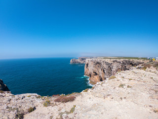 Fototapeta na wymiar Praya de Marinha most beautiful beach in Algarve, Portugal. Cliffs on Coast of Atlantic ocean against blue sky 