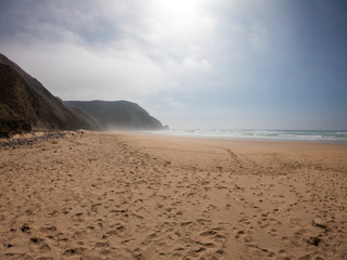 Praia de Castelejo beautiful beach for surfers on west coast of Portugal. Coast of Atlantic ocean amidst mountains 
