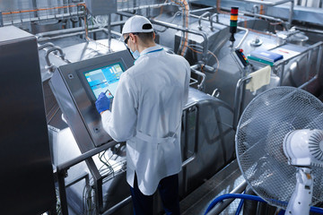 man in a white robe and a cap make a configure the digital screen