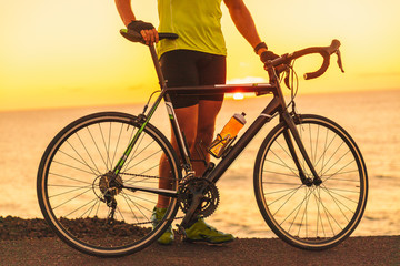 Fototapeta na wymiar Professional triathlete man training with road bike biking at ocean sunset for triathlon race. Male athlete cyclist.