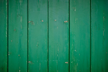 Grünes Holzbrett, Grüner Hintergrund, Grüne Holzbalken. Altes grünes Schäunentor mit abgesplitterten und rauen Stellen. Holz Hintergrund mit leichte dunkler Vignette an den Rändern.