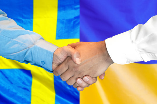 Business handshake on the background of two flags. Men handshake on the background of the Sweden and Ukraine flag. Support concept