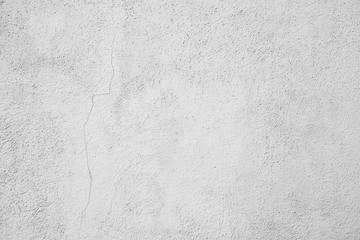 Hellgrauer Hintergrund, Industrial Design. Verputzte Mauer mit einem Riss in der linken Bildhälfte, Raue Struktur und leichte Verschmutzungen. Texturierte Steinwand als gestalterisches Element.