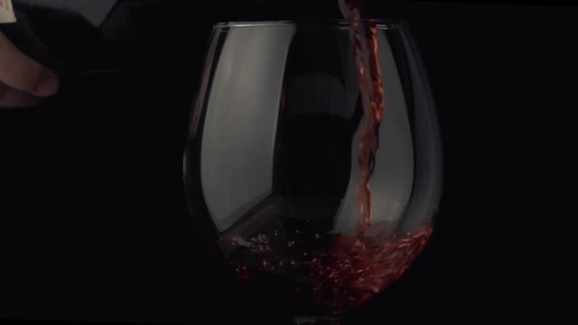 pouring wine from a bottle into a glass slow motoin