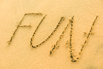 Signs on sand beach written by hand, inspire to travel to exotic islands and relax. Words Ocean, fun, happy and smile on yellow beach. Family tour travel time in summer resort. Enjoy your holidays