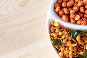 South indian spicy crunchy mix Nimco or Namkeen and spicy coated peanut white bowl wooden background.