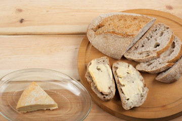 Many mixed breads and rolls of baked bread on wooden table background.