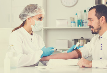 Female nurse injecting male patient