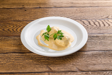 Fish meatball with white sauce isolated on wooden background