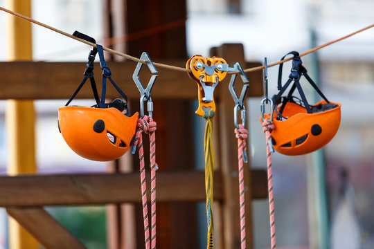 Orange Helmets and Strapping in the rope park. Adult and kids equipment for climbing in the adventure rope park. Active lifestyle for kids.
