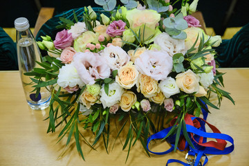 Flowers and a bottle of water on the table of the business conference participant. Bouquet on the...