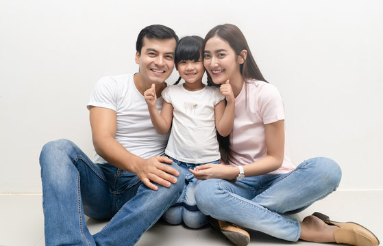 Portrait Of Happy multiethnic family sitting on floor with children and looking at camera. Family and childhood concept