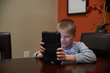 Boy using tablet indoors to learn. 
