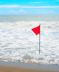 Waving red flag at seashore