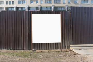 information board near the iron fence in front of the construction site, mock-up
