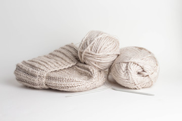 Fototapeta na wymiar Wool yarn in rolls, a ball of wool and a handmade knitted hat in a basket