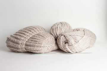 Fototapeta na wymiar Wool yarn in rolls, a ball of wool and a handmade knitted hat in a basket