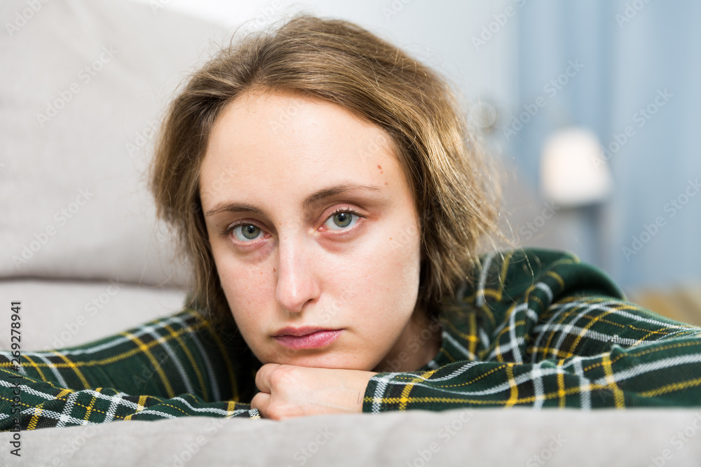 Wall mural portrait of sorrowful woman sitting at home