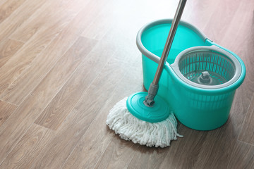 Home wet cleaning concept background. Bucket with a mop on a floor.