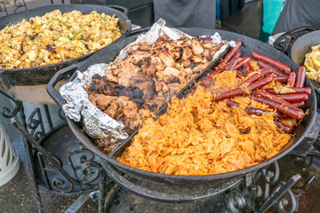 Street food cooked in a large frying pan.