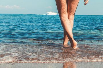 Women's beautiful sexy legs on the beach