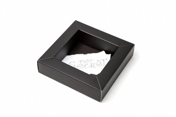Black cardboard box with a sheet of paper inside which is written Top secret with a pencil. On a white background, isolated