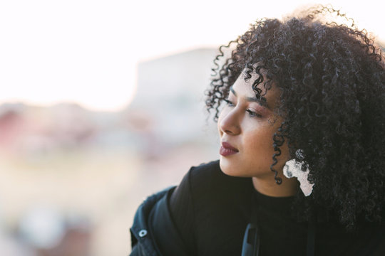Portrait of young woman with curly black hair