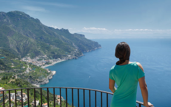 Woman leaning on railing by Amalfi Coast, Italy