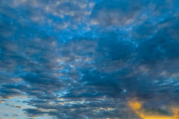 Fototapeta na wymiar The sky with dark clouds illuminated by the setting sun