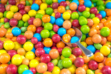 Fototapeta na wymiar Top view of colorful candies with spoon