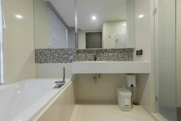 Condo bathroom design with single vanity cabinet and grey tiles on the walls.