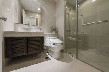 Condo bathroom design with single vanity cabinet and grey tiles on the walls.