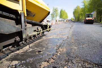 Repair of roads.  Laying asphalt using a roller.