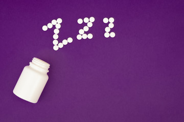 Inscription zzz made from white pills spilling from pill bottle on violet background