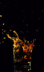 Isolated shot of whiskey with splash on black background