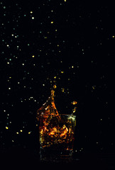 Isolated shot of whiskey with splash on black background