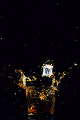 Isolated shot of whiskey with splash on black background