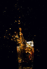 Isolated shot of whiskey with splash on black background