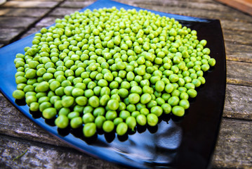 Green peas on wooden background