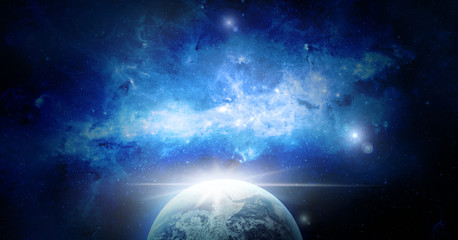 Space with the sunrise on Earth with blue nebula. Elements of this image furnished by NASA.
