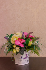 A bouquet of artificial flowers in a pot on the table. The decor of the interior. . Flowers in a pot. Beautiful flowers