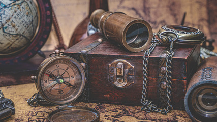 Fototapeta na wymiar Antique Bronze Telescope, Compass And Old Collection On Treasure Box