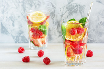 Refreshing summer drinks. Lemonade with berries, mint and lemon. Two tall glasses. Bright photo with space for text.