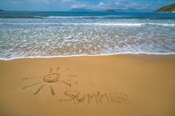Fototapeta na wymiar Image of sun and word summer drawn on sand