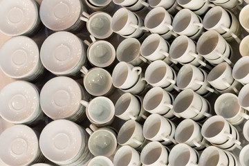 White coffee cups in rows on table. Cup prepared for hot drink such as coffee or tea in local coffee cafe or restaurant