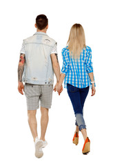  Back view of going couple. walking friendly girl and guy holding hands.