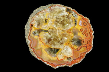 A cross section of the agate stone filled with quartz. Multicolored silica rings colored with metal oxides are visible.